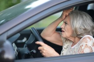 elderly woman driving a car while confused