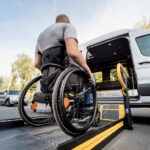 A man in a wheelchair on a lift for an NEMT van